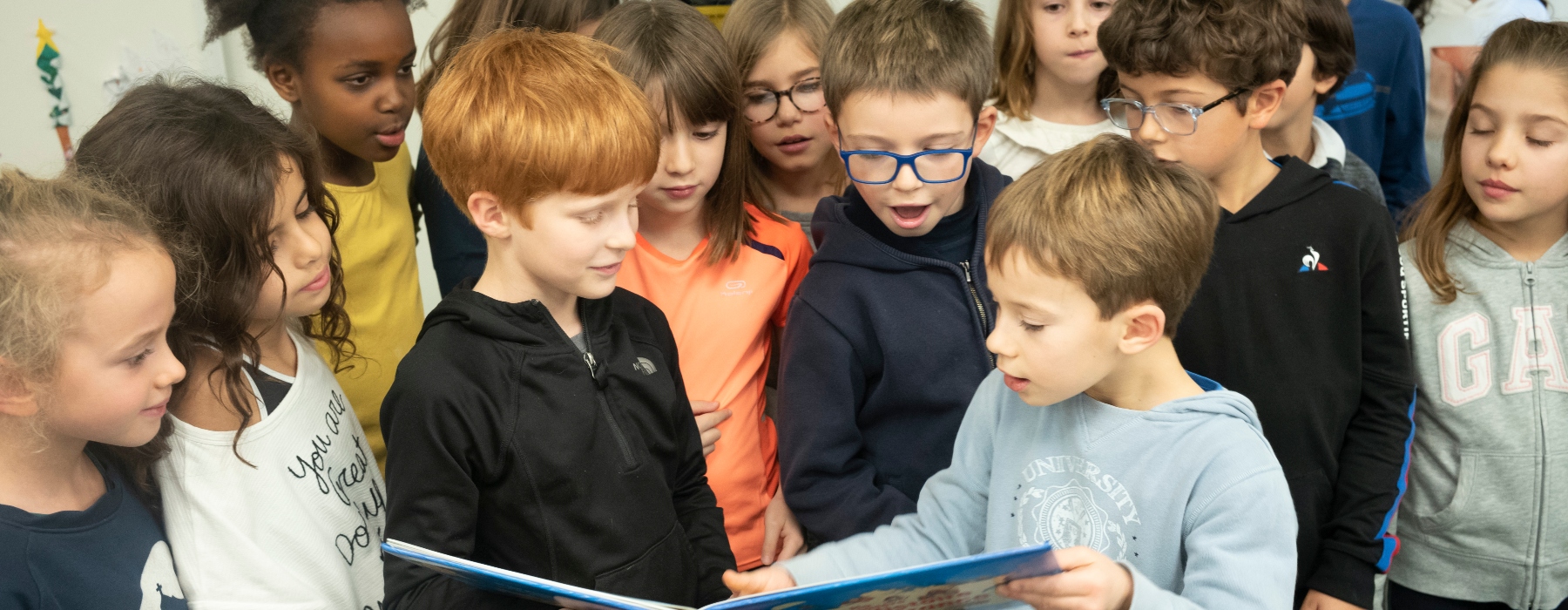 Photo de jeunes élèves lisant ensemble à l'école de Paris